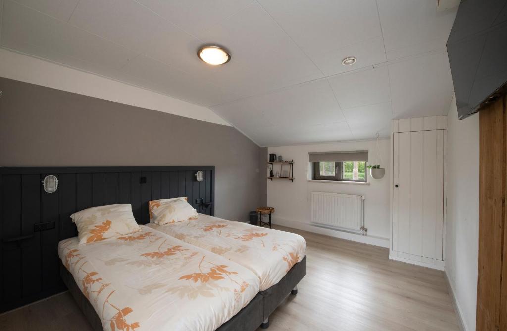 ein Schlafzimmer mit einem großen Bett in einem Zimmer in der Unterkunft Hotel Lamperse Hei in Wanroij