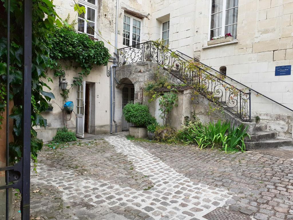 un antiguo edificio de piedra con una escalera junto a un edificio en Studio avec wifi a Chateau Thierry en Château-Thierry