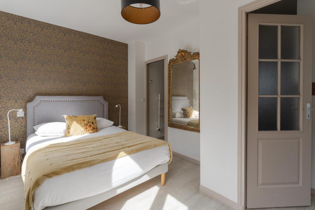a bedroom with a bed and a mirror at Studio et appartements Sainte Catherine in Honfleur