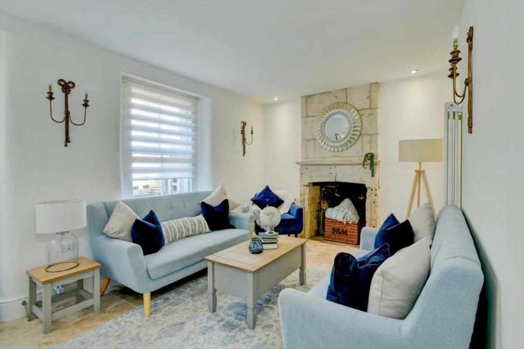 sala de estar con 2 sofás y chimenea en Seven Acres Cottage with Parking en Bath