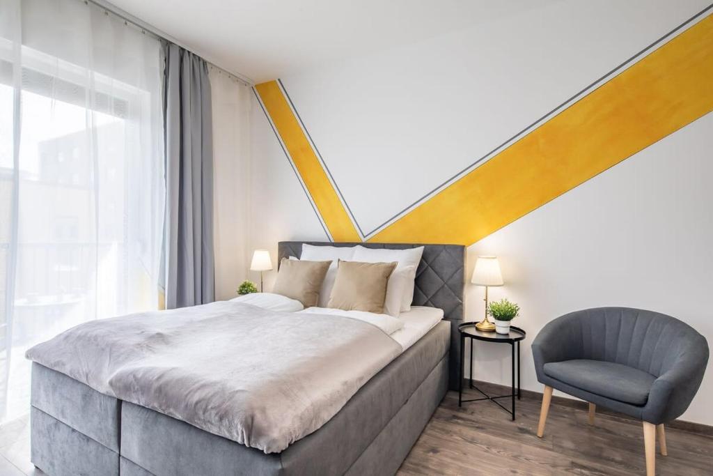 1 dormitorio con 1 cama grande y 1 silla en Modern Comfy Stay next to the River en Budapest