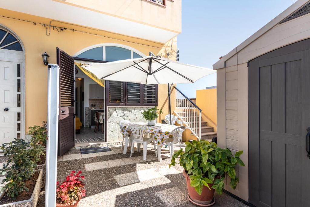 eine Terrasse mit einem Tisch und einem Sonnenschirm in der Unterkunft Casa Pazza in Avola