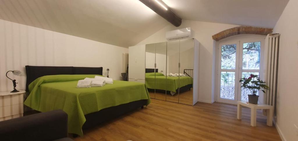 een slaapkamer met een groen bed en een spiegel bij LUCKY HOME CITTÀ ALTA in Bergamo