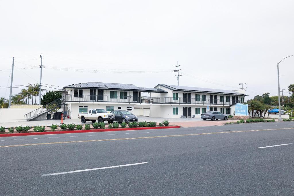 een groot wit gebouw met auto's geparkeerd voor het bij Hotel Miramar in San Clemente