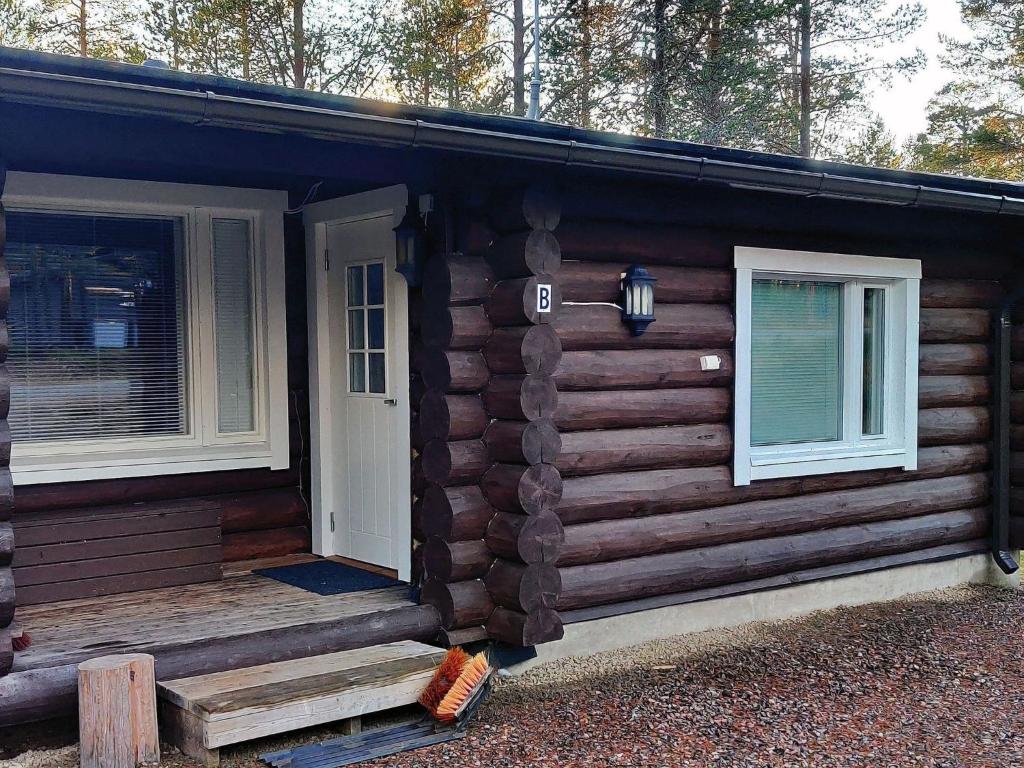 uma cabana de madeira com uma porta e duas janelas em Holiday Home Vahtamantie 8 b by Interhome em Saariselka