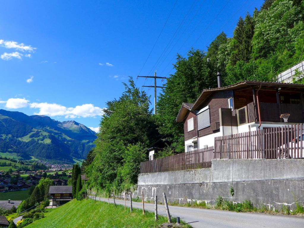 ein Haus auf einem Hügel neben einer Straße in der Unterkunft Holiday Home Chalet Guldeli by Interhome in Kandergrund