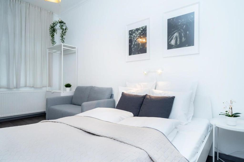 een witte kamer met een bed en een bank bij Ideal new apartment in the center in Boedapest
