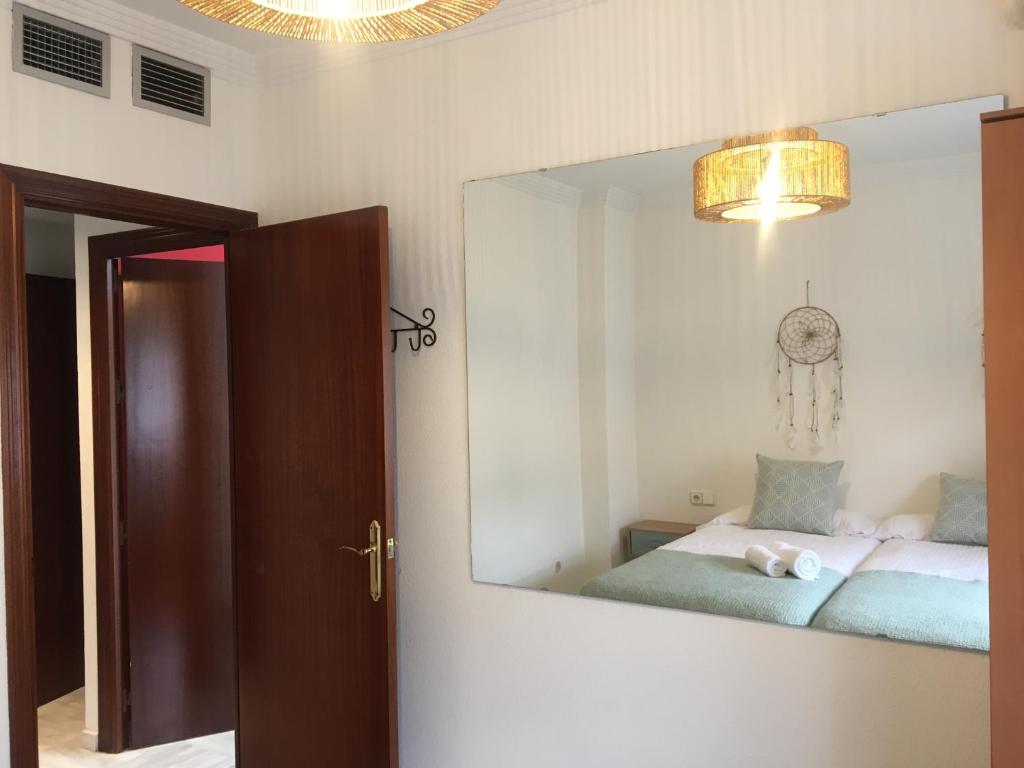 a bedroom with a mirror and a bed in a room at Alojamiento Seda in Alcalá de Guadaira