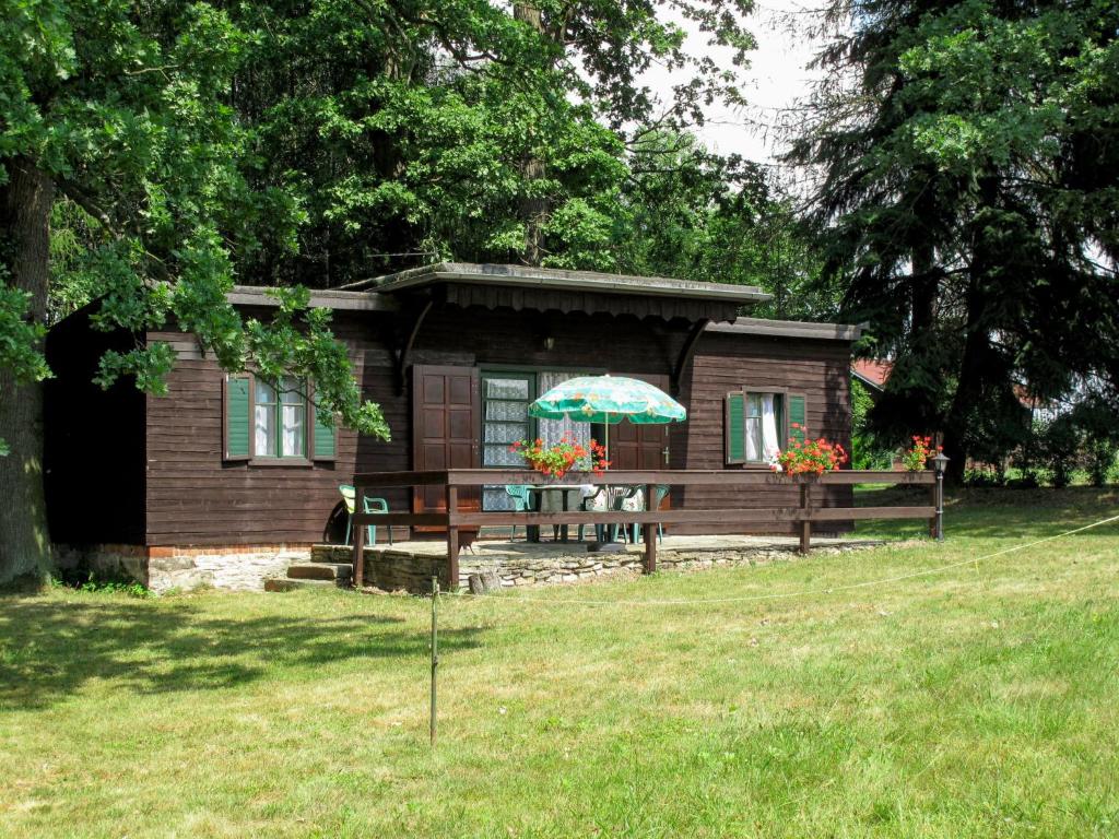 eine kleine Hütte mit einem Tisch und einem Sonnenschirm in der Unterkunft Holiday Home Marta - ZAB100 by Interhome in Červený Kostelec