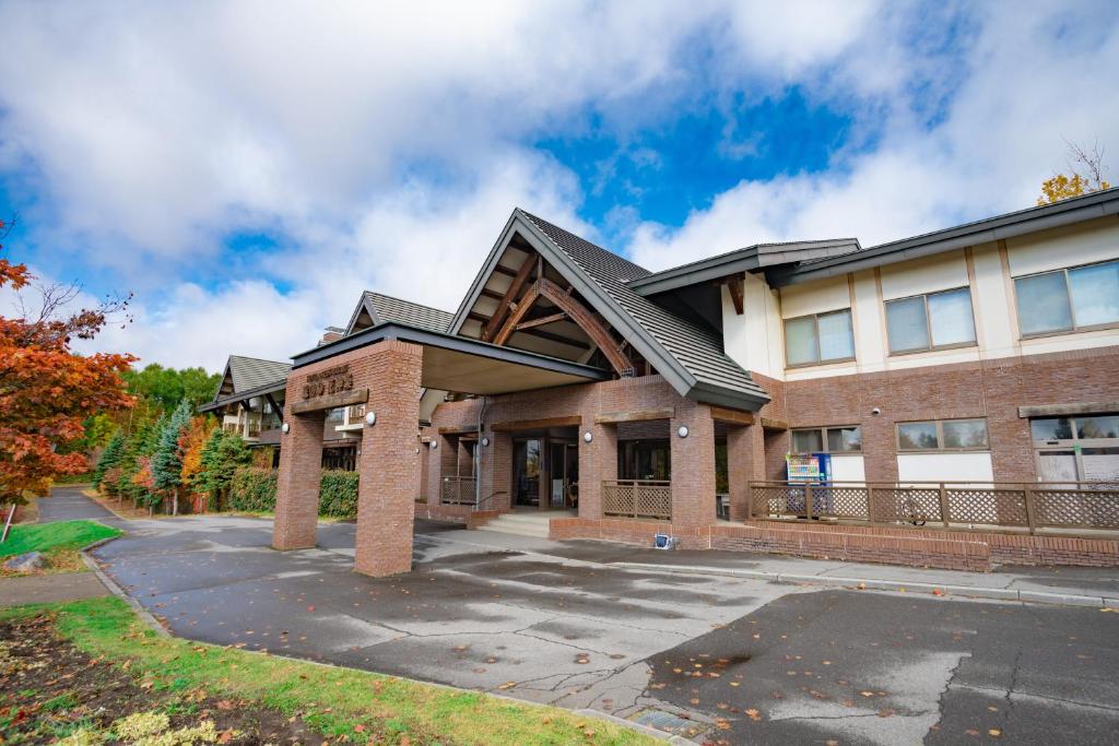 un edificio con un estacionamiento delante de él en Morinoyu Hotel Hanakagura, en Asahikawa