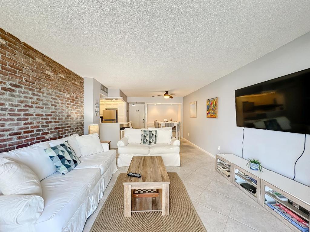 a living room with a white couch and a brick wall at Beach Front Condo In Paradise Marco Island in Marco Island