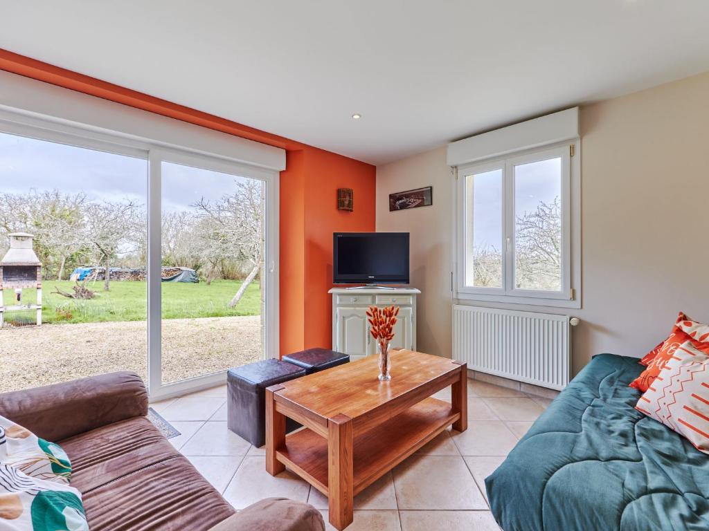 ein Wohnzimmer mit einem Sofa und einem Tisch in der Unterkunft Holiday Home Le Lanchon - LVT402 by Interhome in Le Vrétot
