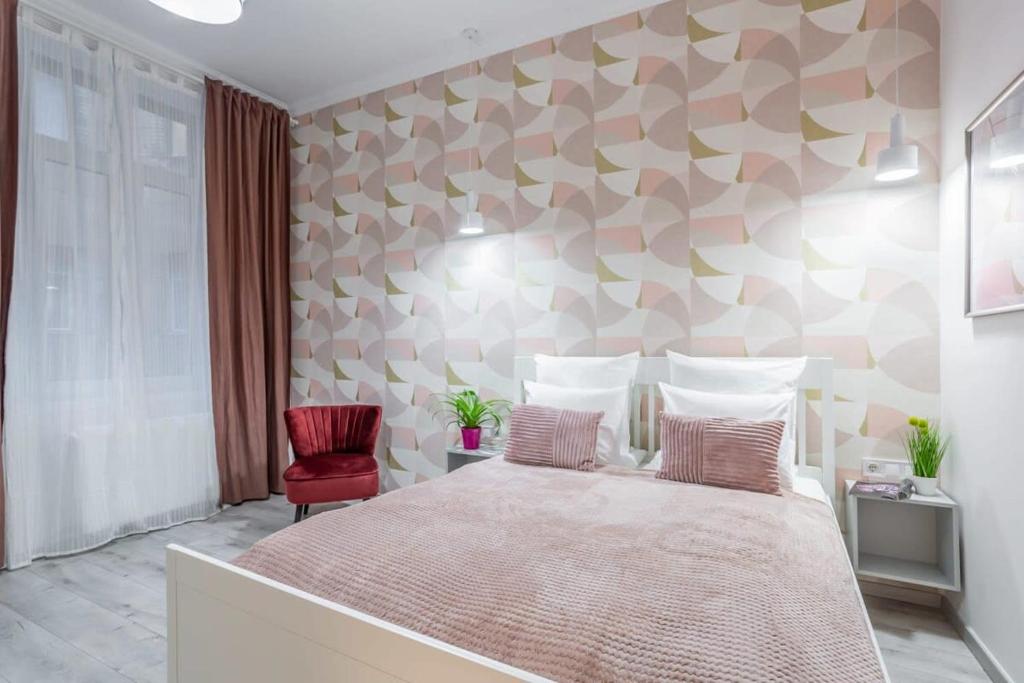 ein Schlafzimmer mit einem großen Bett und einem roten Stuhl in der Unterkunft Gorgeous & Super Central Studio in Budapest