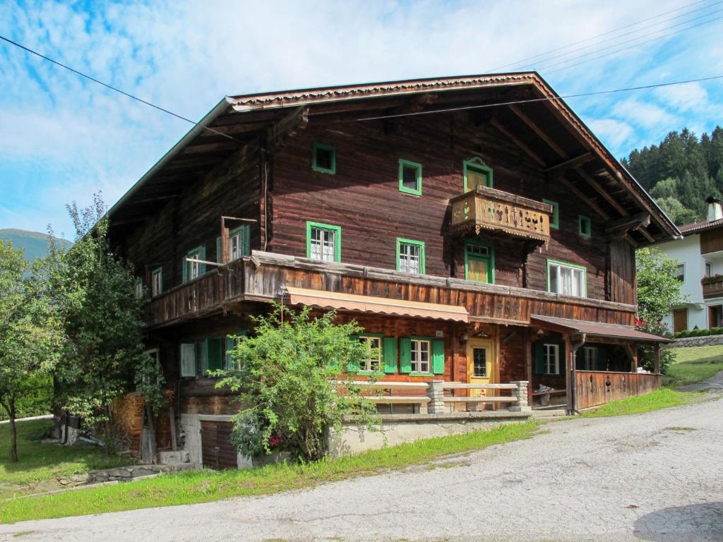 Cette grande maison en bois est dotée de portes et de fenêtres vertes. dans l'établissement Holiday Home Geislerhütte - MHO685 by Interhome, à Ramsau im Zillertal