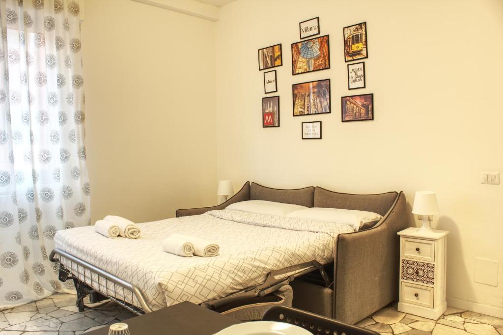 - une chambre avec un lit et des photos sur le mur dans l'établissement 50 metri da Fiera Milano - Business Friendly, à Milan