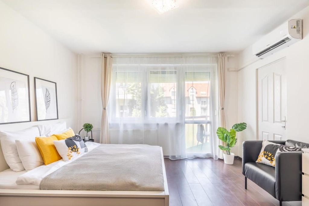 um quarto com uma cama grande e uma janela em Cute and convenient Apartment em Budapeste