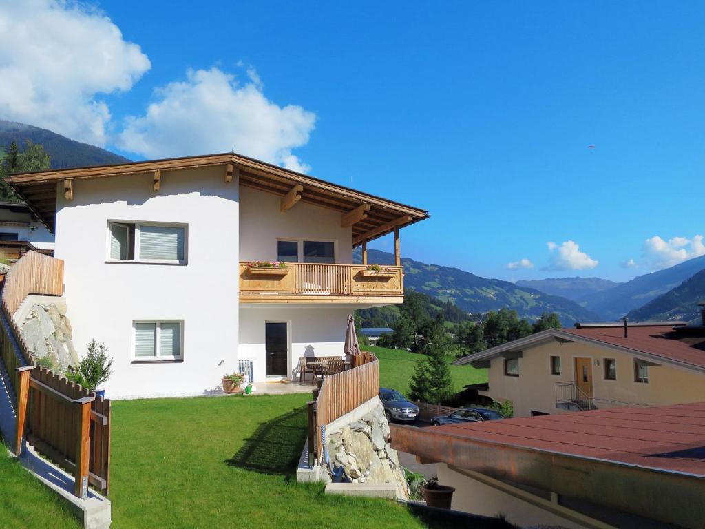 a white house with a balcony and mountains in the background at Apartment Tamerl - MHO160 by Interhome in Schwendau