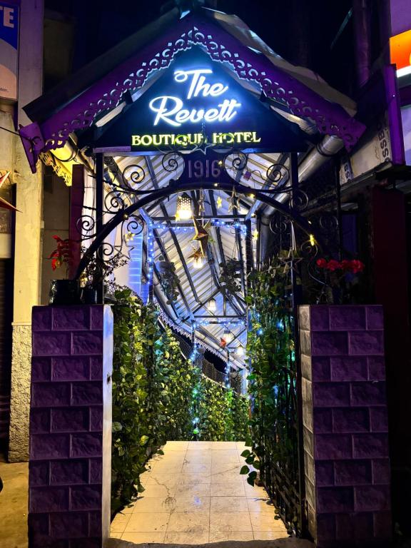 a building with a blue sign and some plants at The Revett in Darjeeling