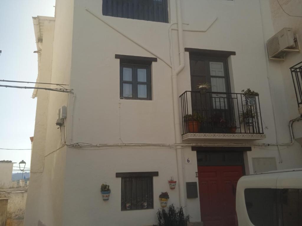 a white building with a red door and windows at Casa Carrie in Válor