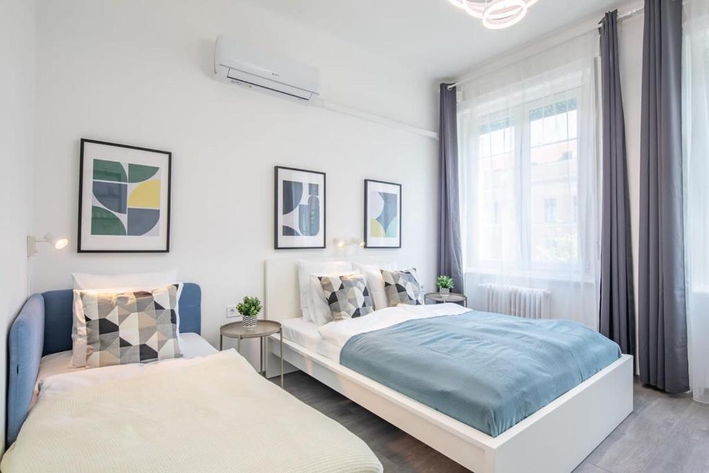 een slaapkamer met twee bedden en een raam bij Newly designed central studio in Boedapest