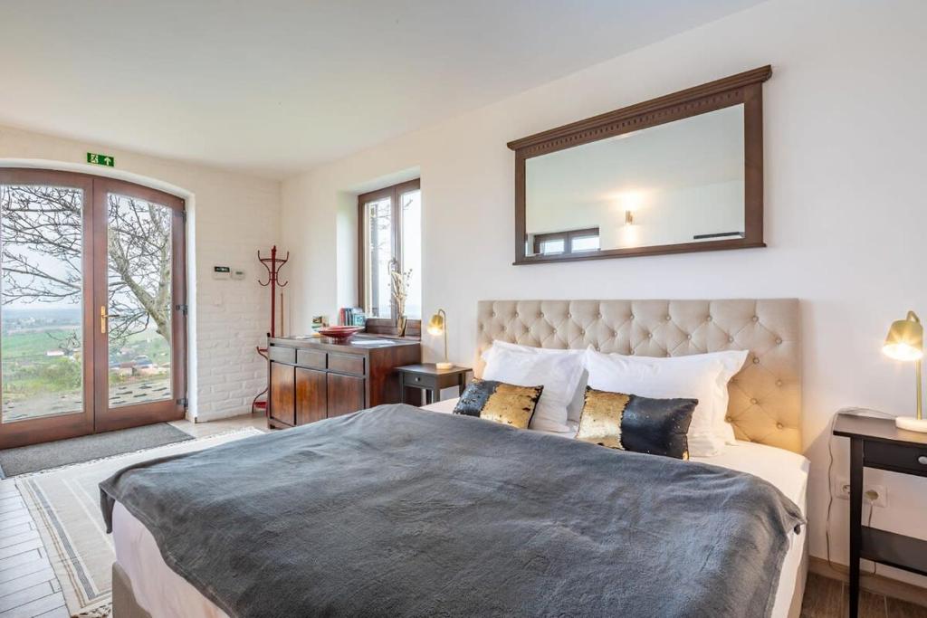 1 dormitorio con 1 cama grande y espejo en la pared en Perfect relax en Somlószőlős