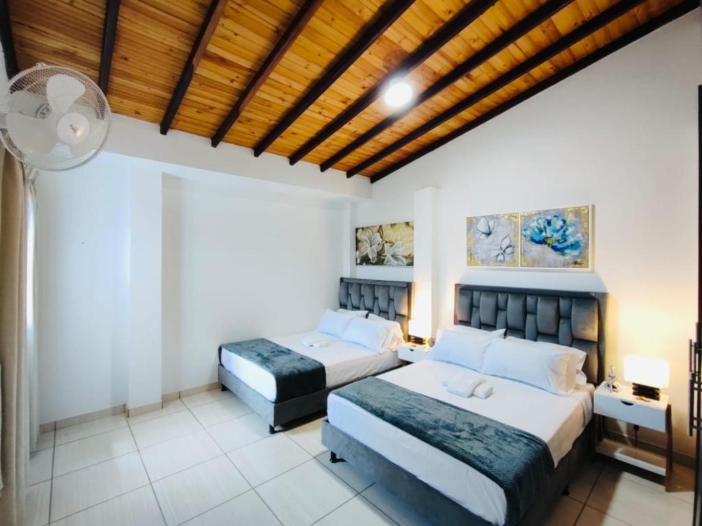 a bedroom with two beds and a wooden ceiling at ApartaHostal Quintanilla in Villanueva