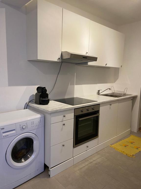 a kitchen with a washing machine and a washer at Quartos em Setúbal in Setúbal