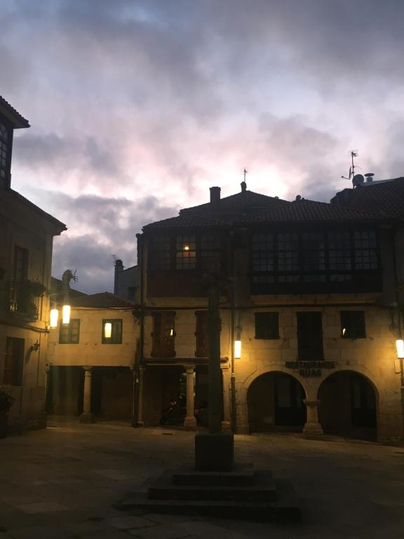 an old building with a sunset in the background at Casa emblemática Rosarillo Plaza de la Leña in Pontevedra