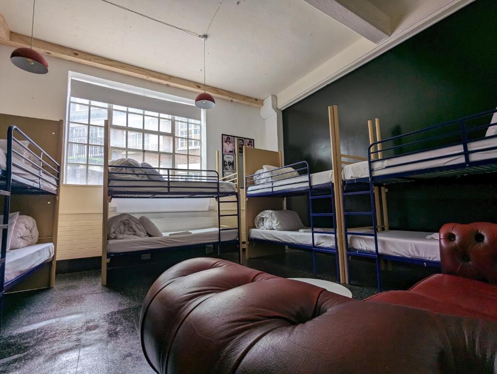ブリストルにあるロックン ボウルの複数の二段ベッドとソファが備わる客室です。