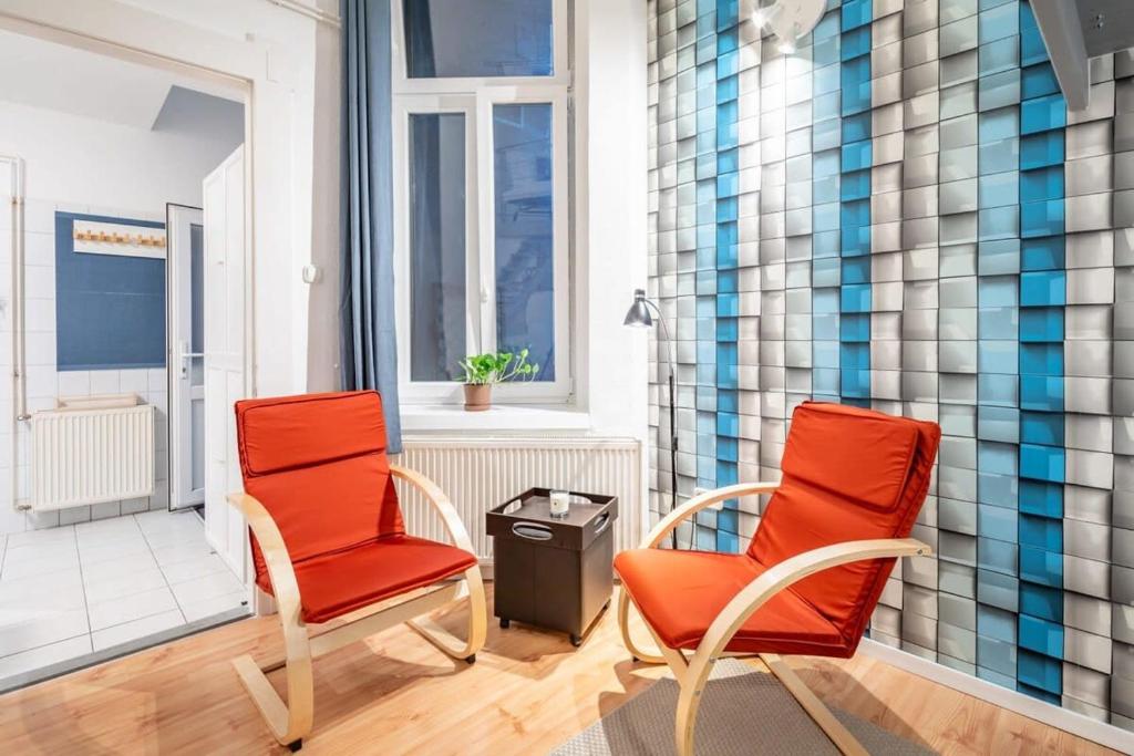 2 orangefarbene Stühle in einem Zimmer mit Fenster in der Unterkunft Central Cozy Home in Budapest