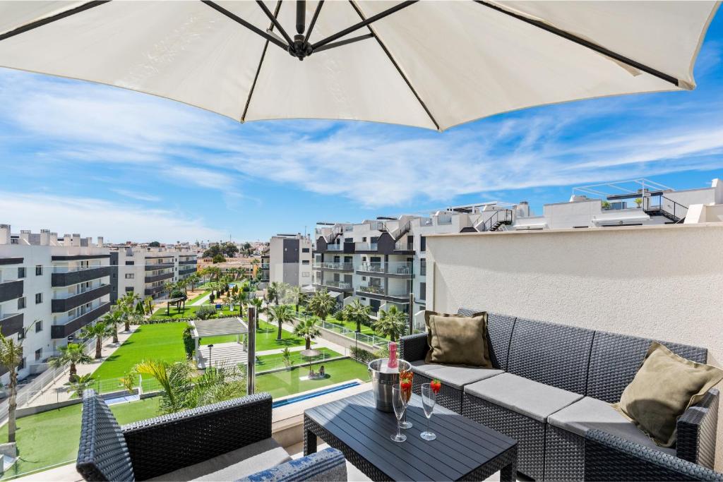 een patio met een parasol en een tafel op een balkon bij Baliante - penthouse, 2 bedrooms, 2 pools, jacuzzi, Orihuela Costa in Orihuela