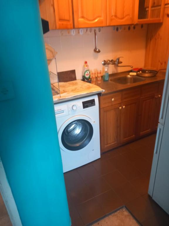 uma cozinha com uma máquina de lavar roupa e um lavatório em Люлин хаус em Sófia