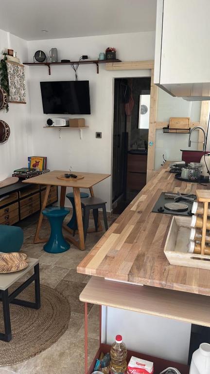 een keuken met een houten tafel in een kamer bij Studio tout confort in Bagneux