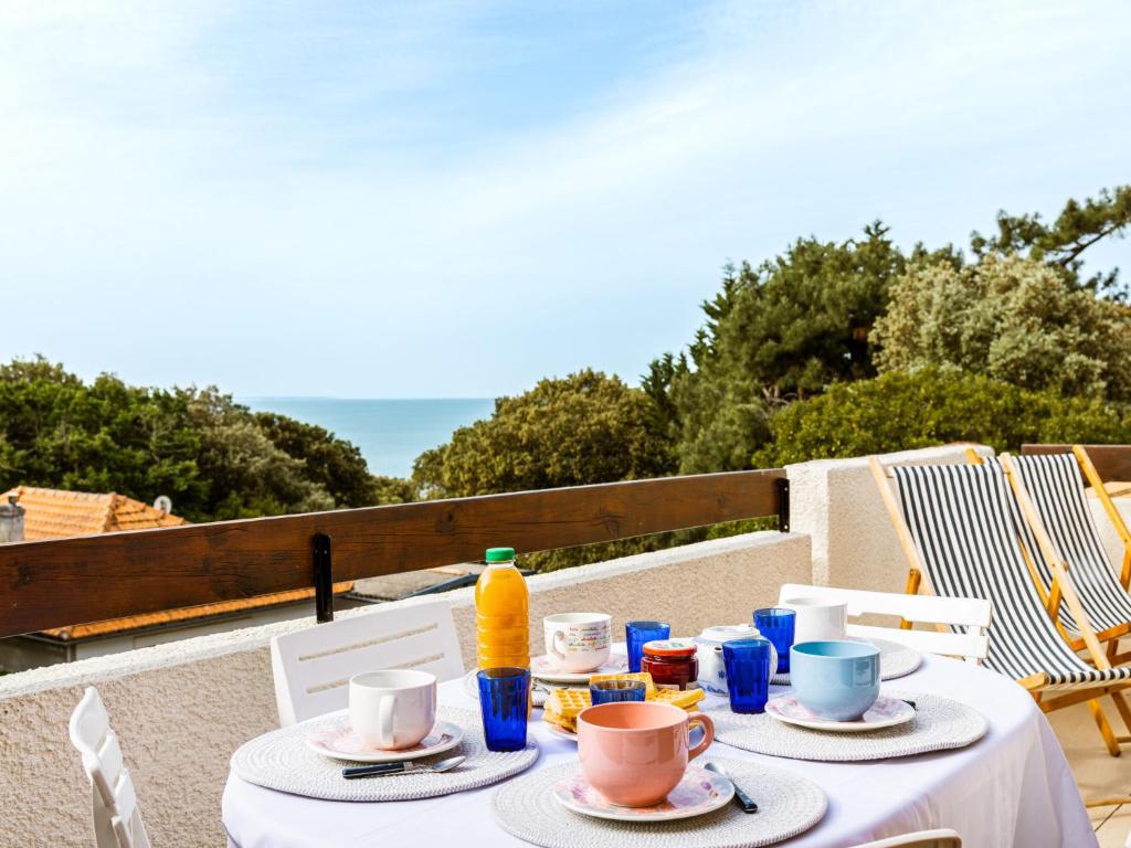 - une table avec des assiettes de nourriture et une bouteille de jus d'orange dans l'établissement Apartment Le Bois du Roy by Interhome, à Saint-Palais-sur-Mer