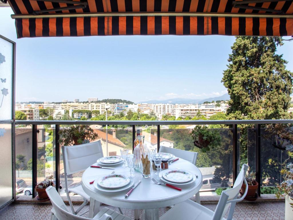 d'une table et de chaises blanches sur un balcon avec vue. dans l'établissement Apartment Parc lautin by Interhome, à Cagnes-sur-Mer