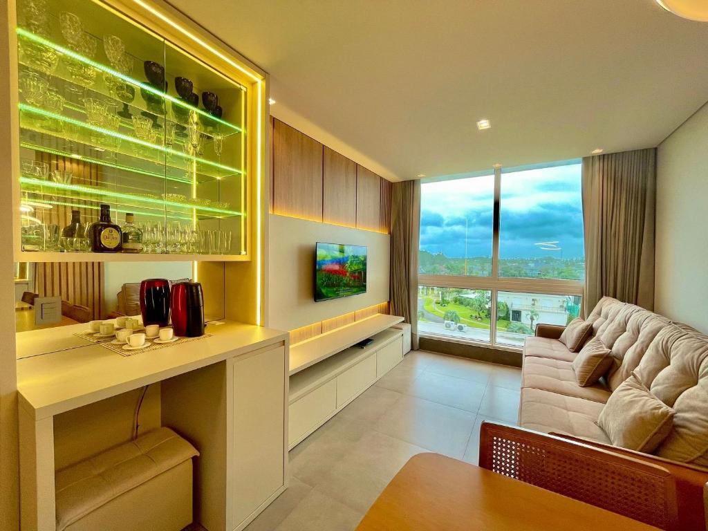 - un salon avec un canapé et une table dans l'établissement Livin' Resort Home - 505/2, à Xangri-lá