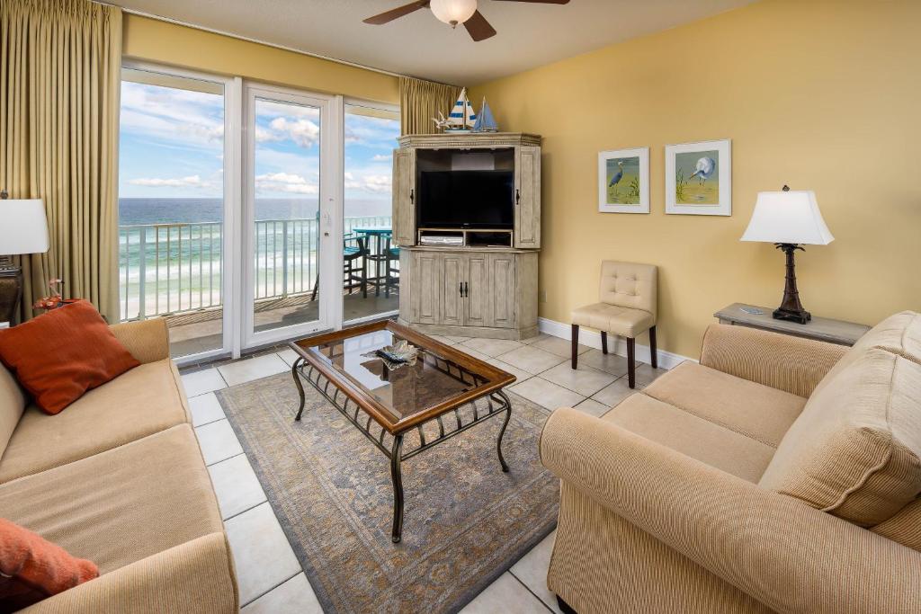 uma sala de estar com um sofá, uma televisão e uma mesa em Sea Dunes 504 condo em Fort Walton Beach