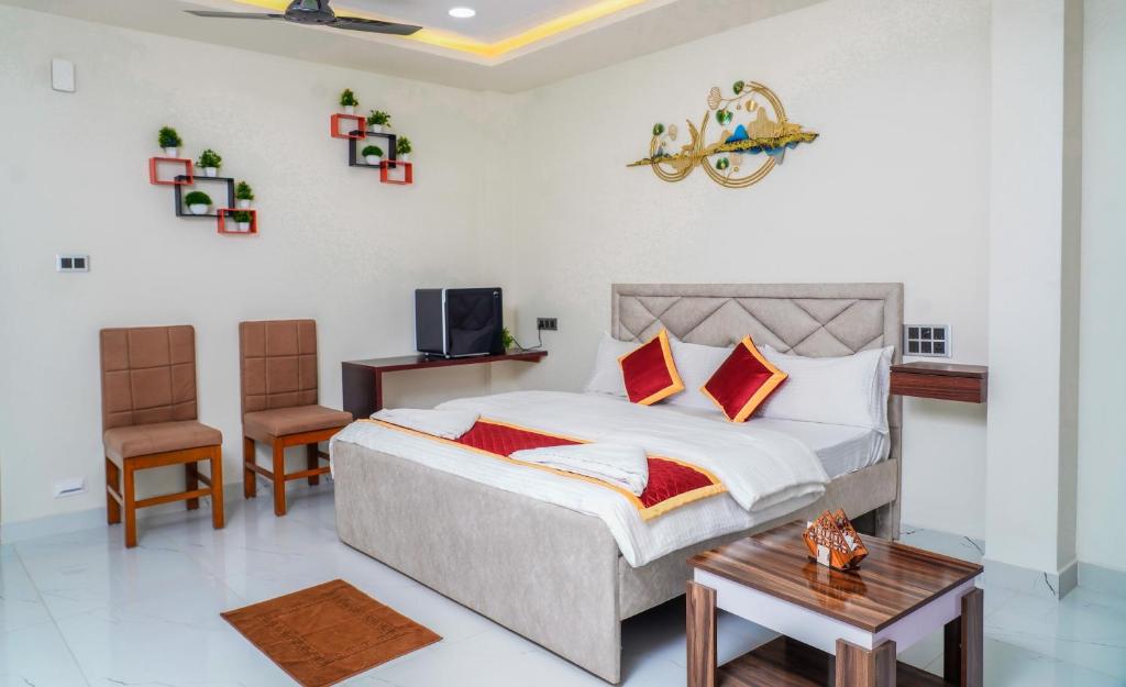 a bedroom with a bed and a table and chairs at HOTEL VASAVI ELITE in Bāpatla