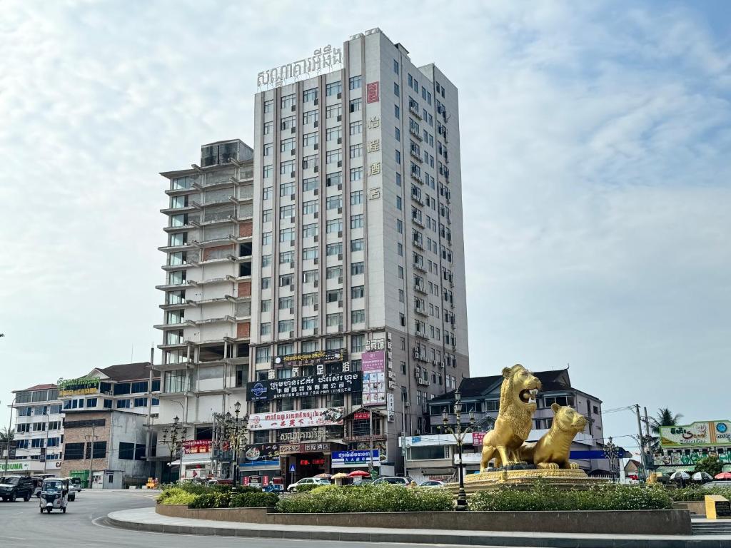 西哈努克的住宿－怡程酒店ECHENG HOTEL，一座高大的建筑,前面有狮子雕像