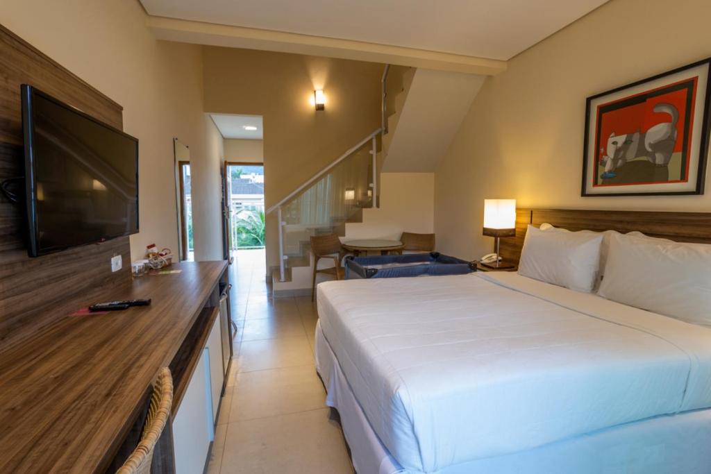 Uma TV ou centro de entretenimento em Amora Hotel Maresias
