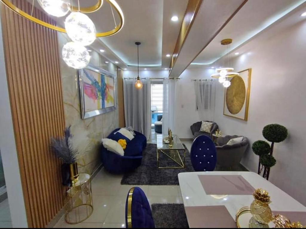 ein Wohnzimmer mit blauen Stühlen und einem Tisch in der Unterkunft APT Estevez in Pantoja