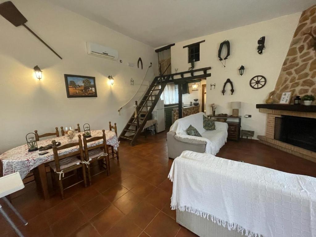 een grote woonkamer met een open haard en een trap bij Finca - Granja " El Chaparral" in Orgaz