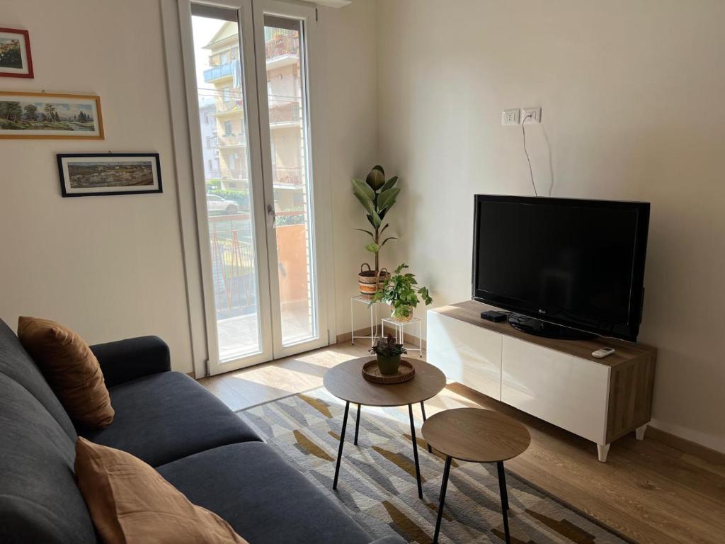 een woonkamer met een bank en een flatscreen-tv bij Orchidea in Modena