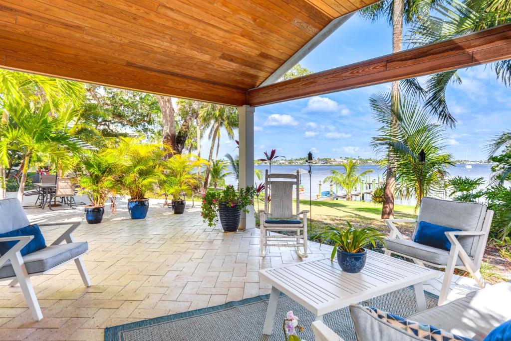 an outdoor patio with chairs and a table at Waterfront Stuart Oasis with Hot Tub and Dock! in Stuart