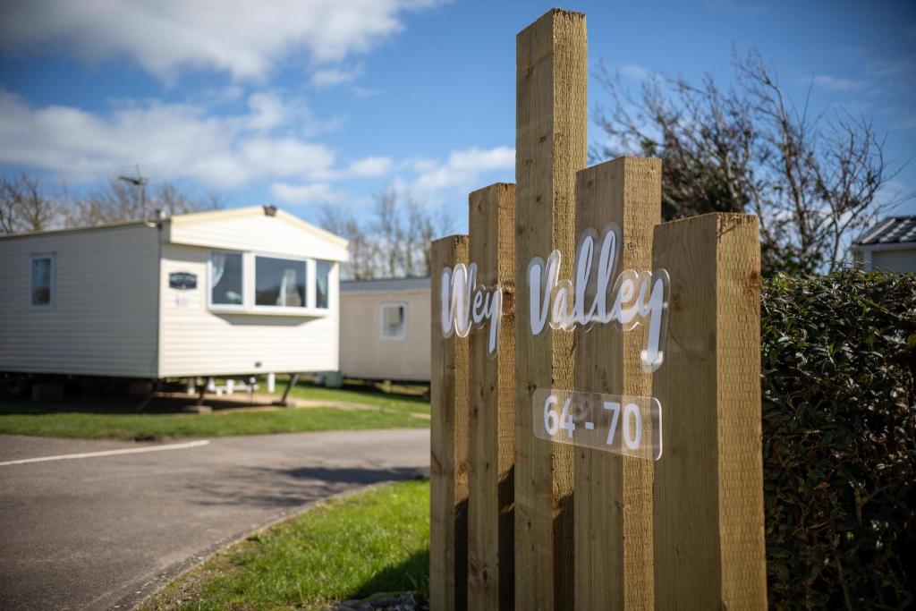 韋茅斯的住宿－Littlesea Caravan，房屋前的 ⁇ 上木标志
