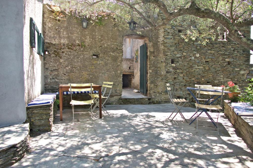 un patio avec une table et des chaises devant un bâtiment dans l'établissement Casa di Pruno, à Morsiglia