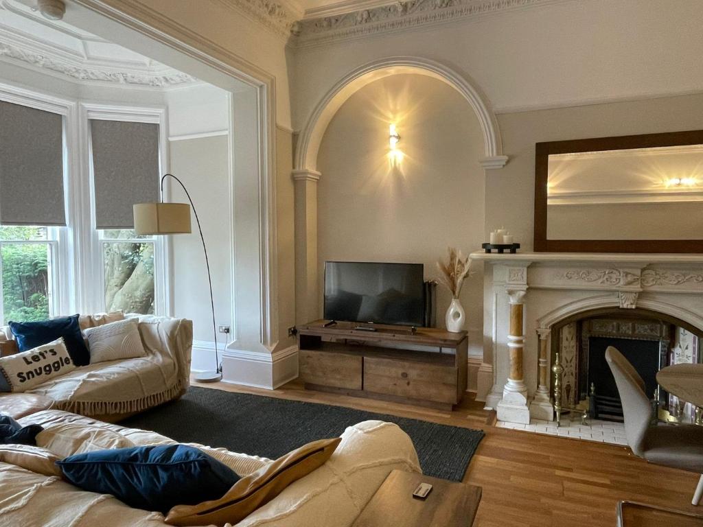 a living room with a couch and a fireplace at Cozy Victorian Gem • Near Hospitals & Attractions in Sheffield