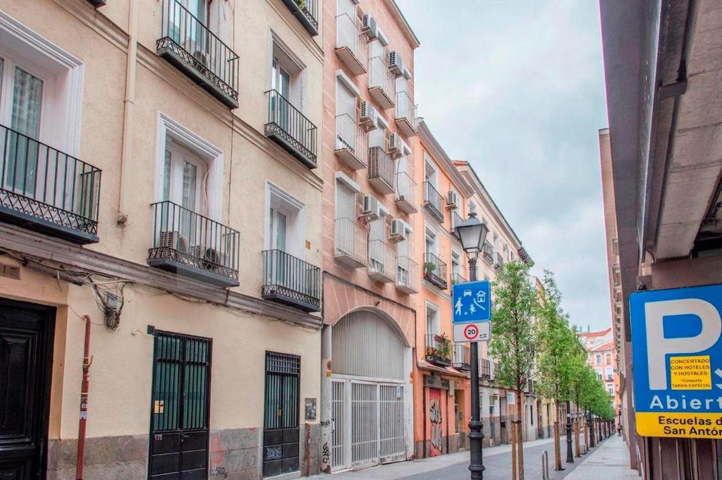 uma rua da cidade com edifícios e um sinal de estacionamento em MIMA Suites Chueca em Madri