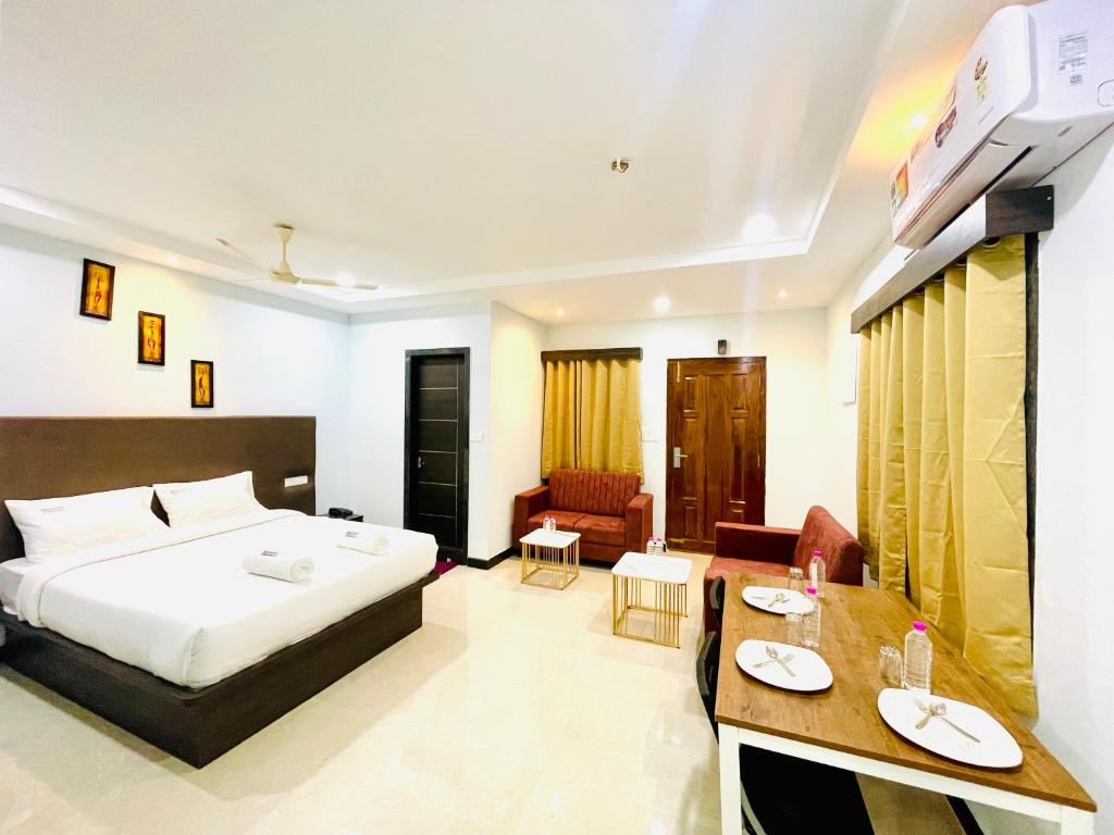 a hotel room with a bed and a desk at Deccan Suites, Tirupati in Tirupati