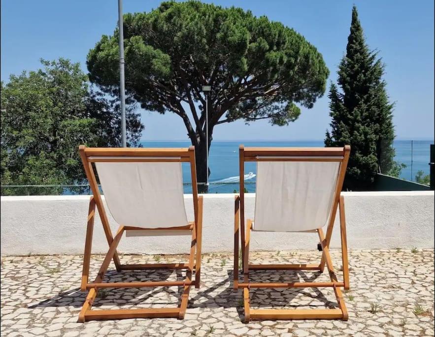 zwei Stühle nebeneinander auf einer Terrasse in der Unterkunft Casa do Portinho in Portinho da Arrábida